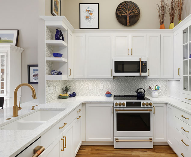 Compact kitchen renovation with white cabinets and gold hardware